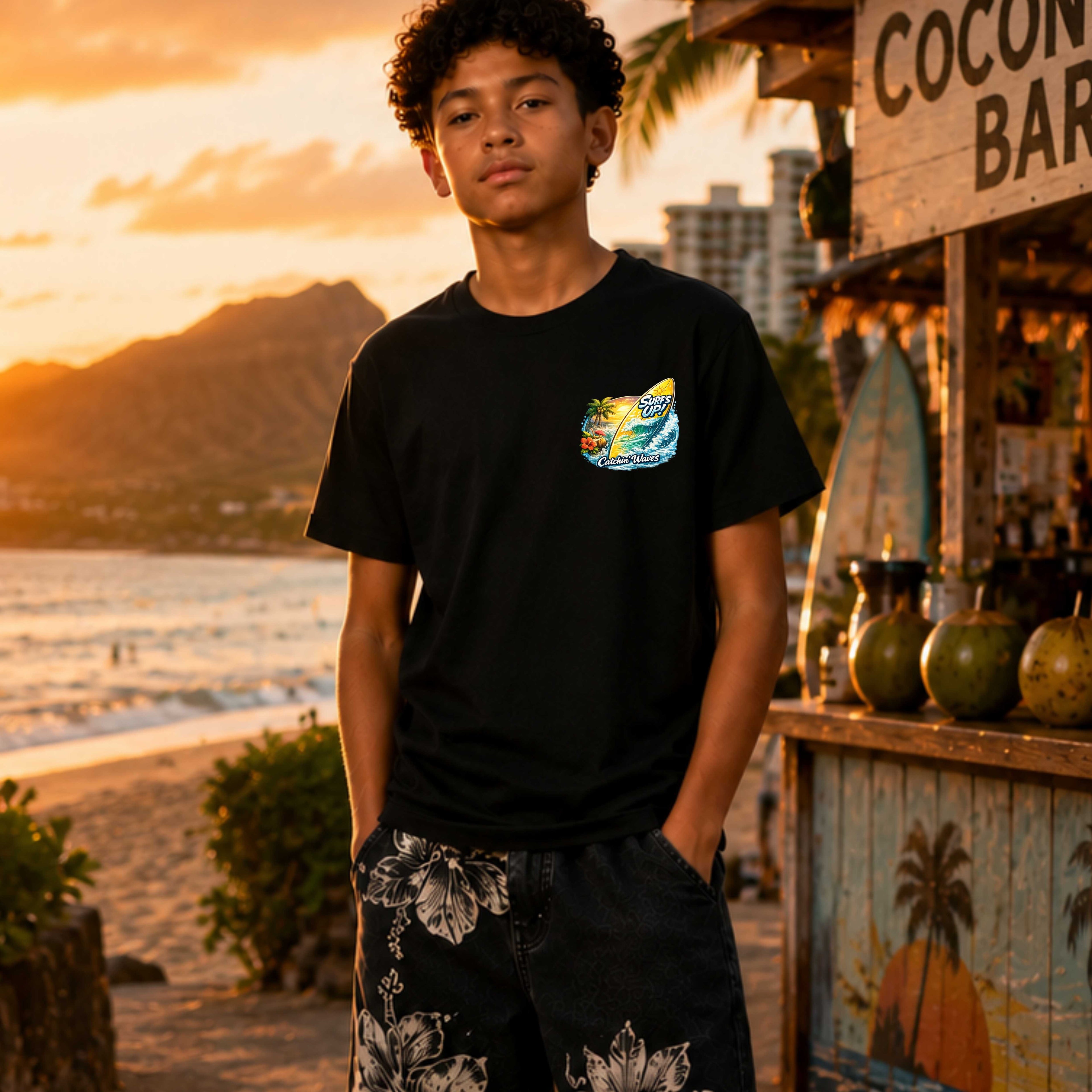 Person wearing a black t-shirt with a colorful graphic on a beach at sunset.
