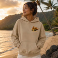 Woman wearing a Sand hoodie with 'Lei' logo on a beach at sunset