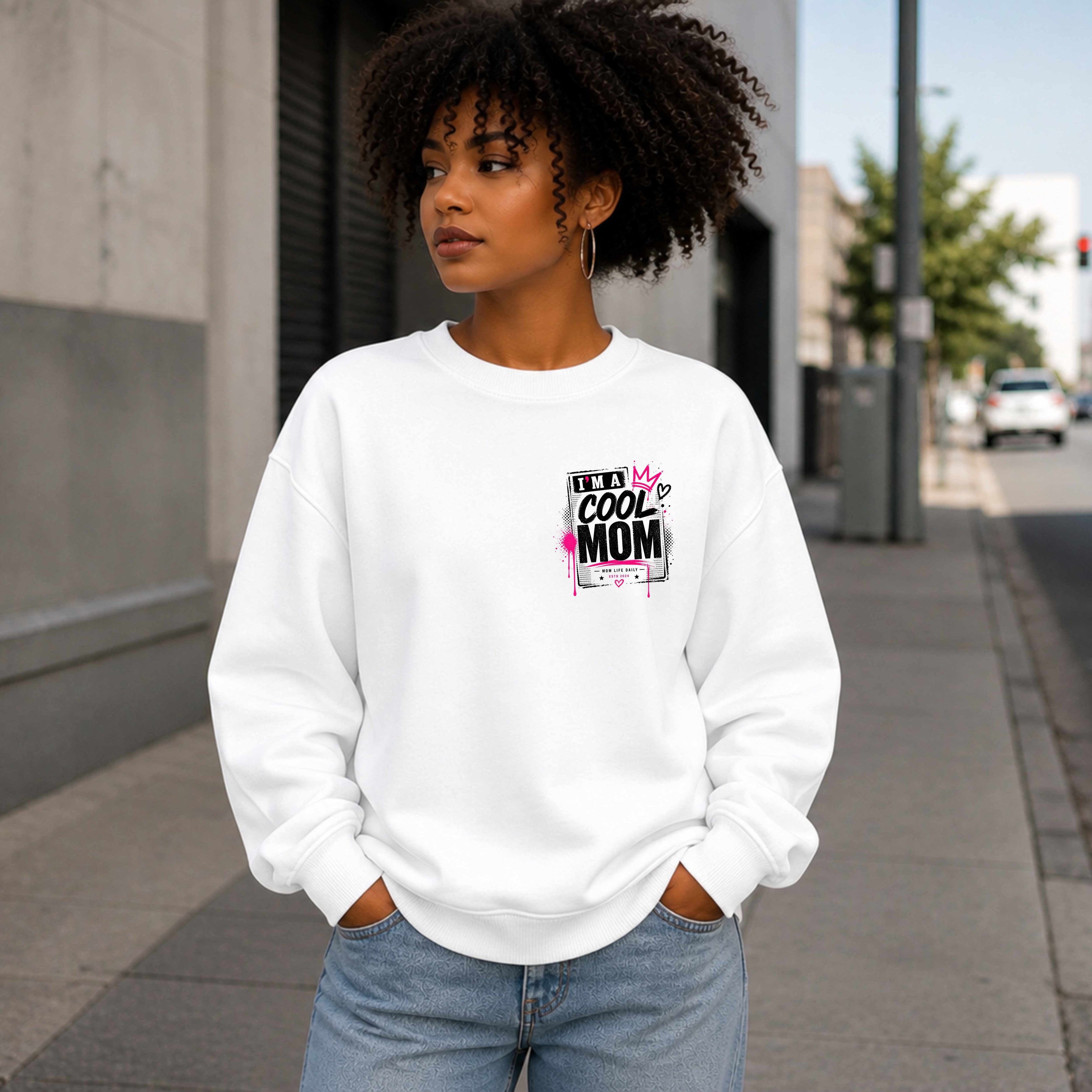 Person wearing a White sweatshirt with a graphic design Say's I'm A  Cool Mom on a city street.