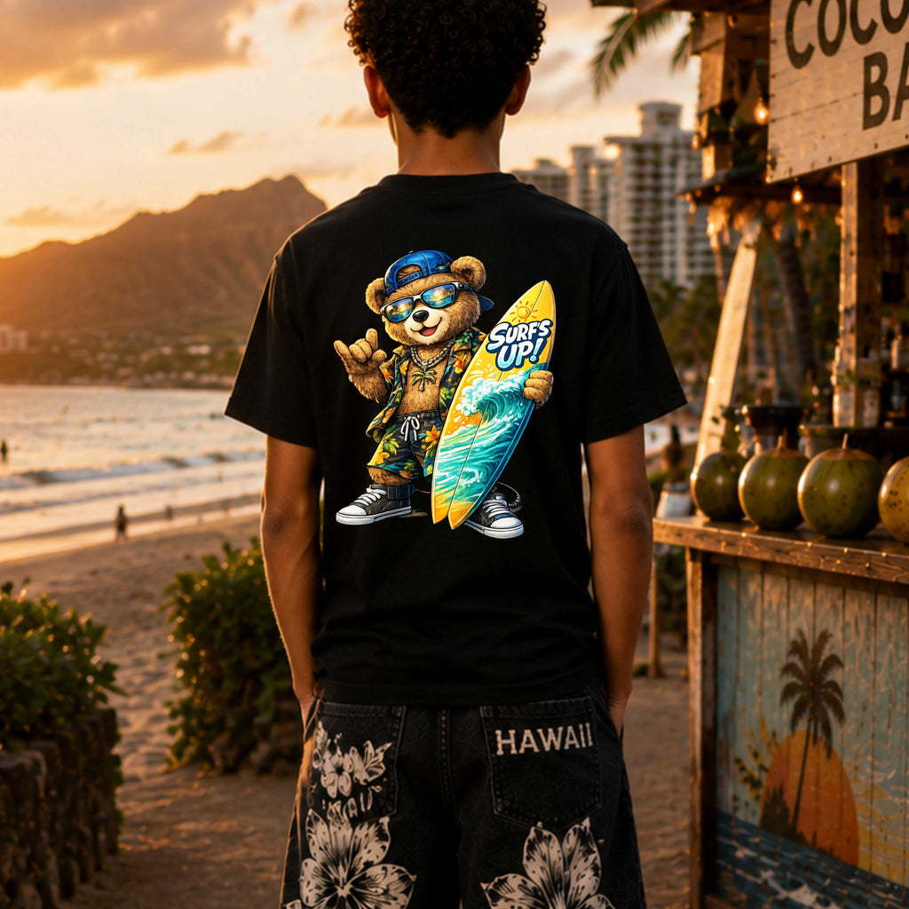 Person wearing a black t-shirt with a bear graphic and 'Surf's Up!' text, standing on a beach at sunset.